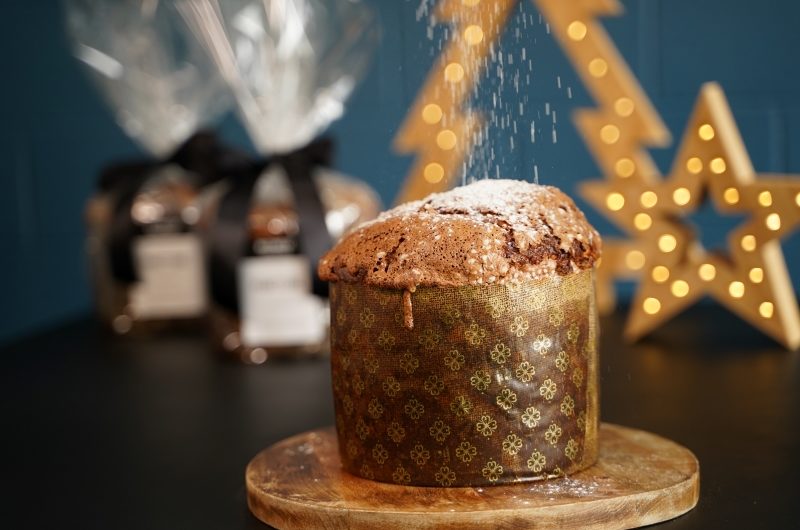 Christmas Panettone A Panettone loaf in the foreground with a light dusting of icing sugar