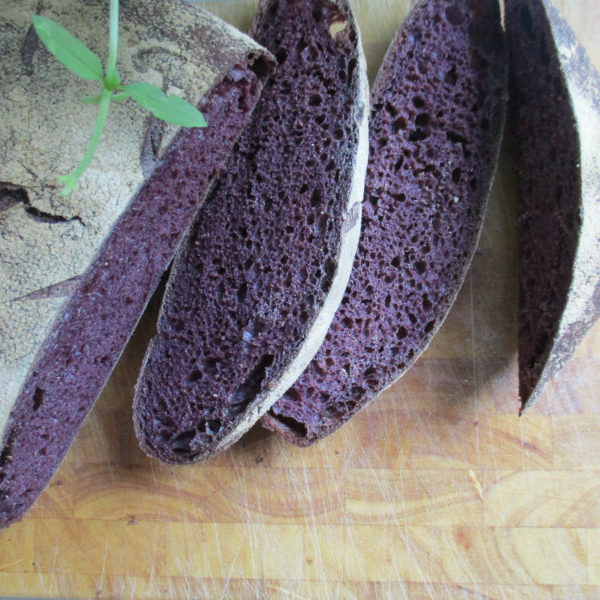 A round loaf of sourdough bread made with purple cornflour