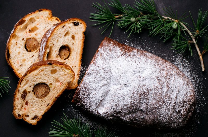 Xmas_Stollen_WEB A loaf of German Stollen bread, dusted with icing sugar with three slices where the round marzipan centre is in the middle of each slice